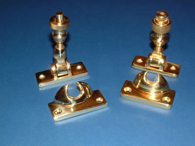 Two polished brass Brighton screw fasteners with their slotted keepers