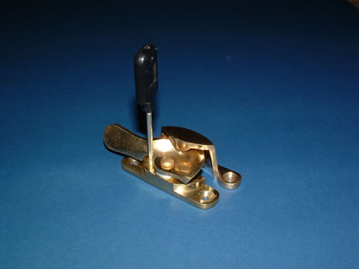 A brass locking Fitch fastener with its key in the lock