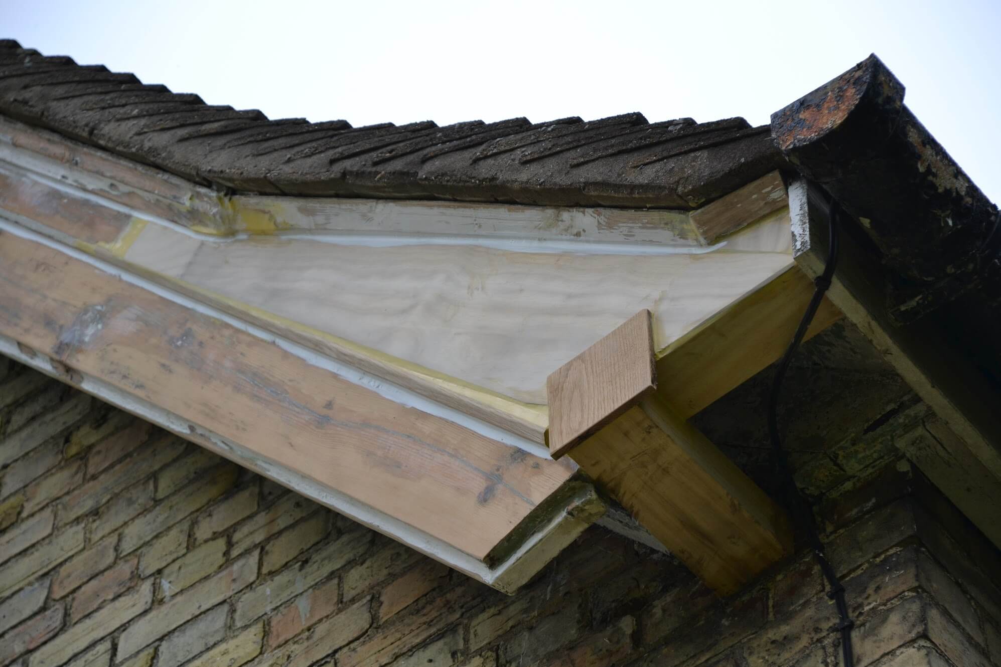 Bargeboard end at the eaves repaired with new, unpainted timber pieces