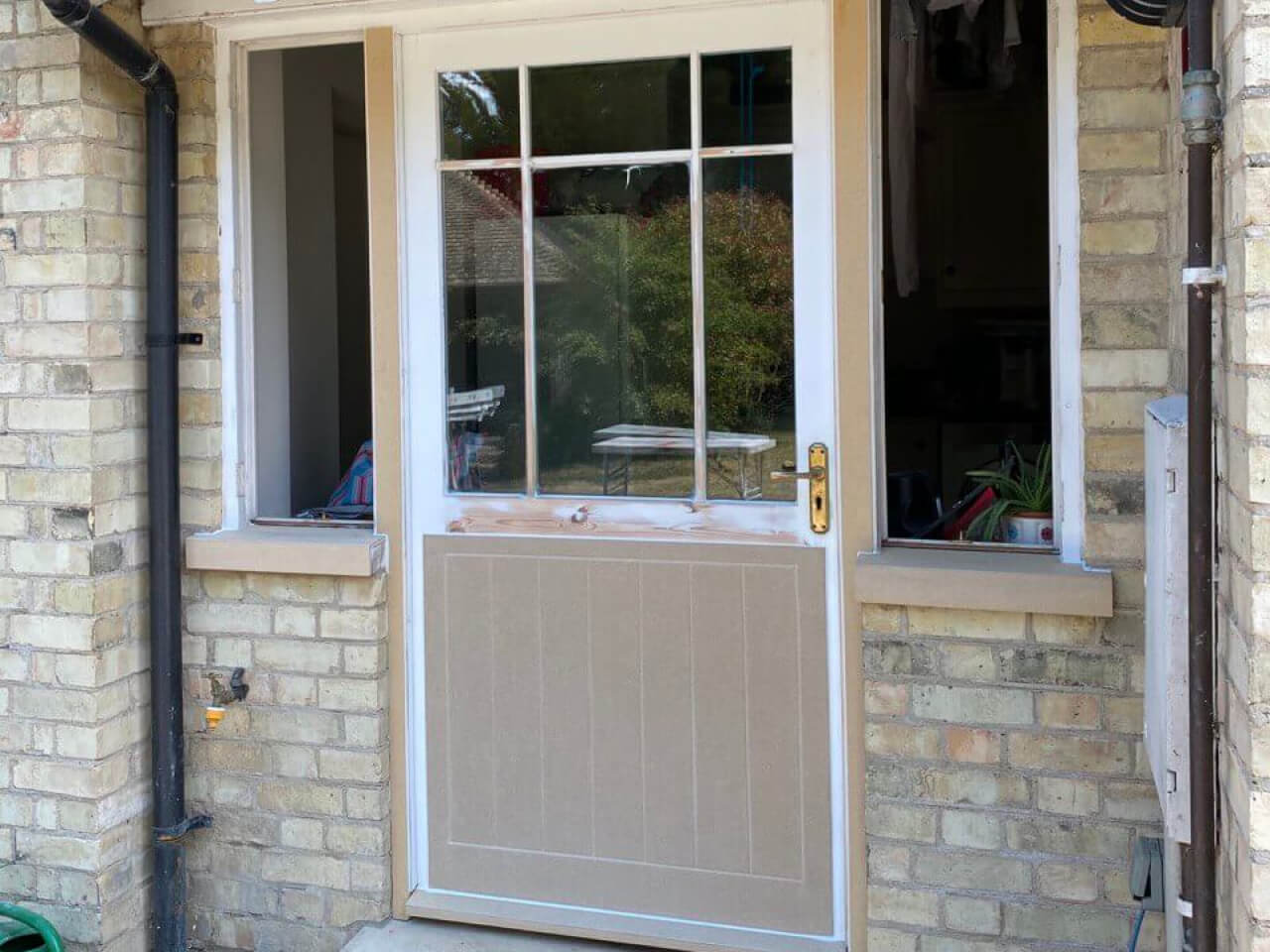 Half-glazed timber door with its lower panel re-faced in new grooved Tricoya board before painting
