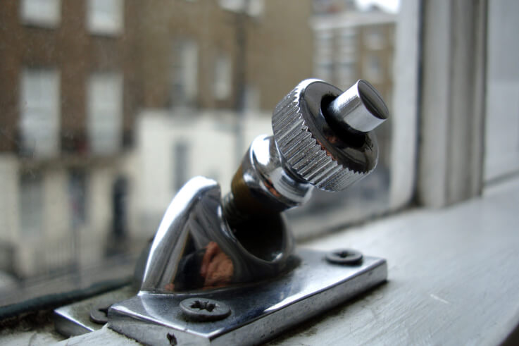A chrome Brighton screw fastener with a knurled knob on the meeting rail of a sash window