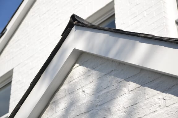 Apex of a gable with white-painted bargeboards over white-painted brickwork