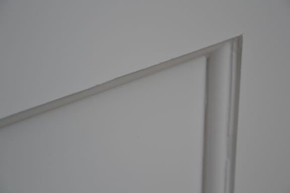 Close-up of a smooth painted finish on a flat panel and its bead moulding