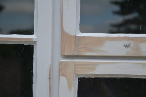 Close-up of casement window joints partly sanded back to bare timber