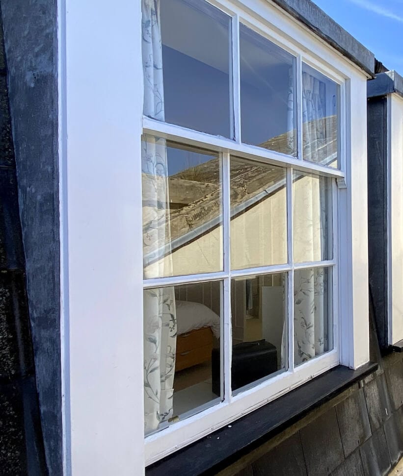A dormer sash window seen from the side, three panes over six