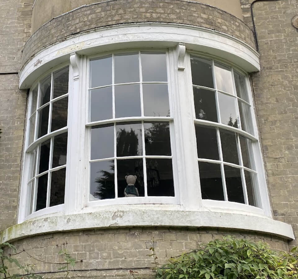 A bow window of curved Georgian-pattern sashes on a gault-brick house