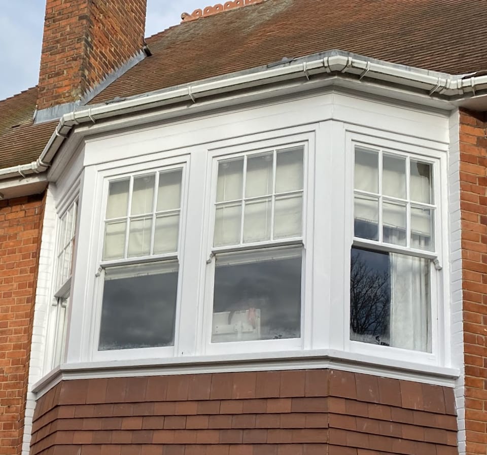 A canted bay of half-Georgian sash windows over a tile-hung base