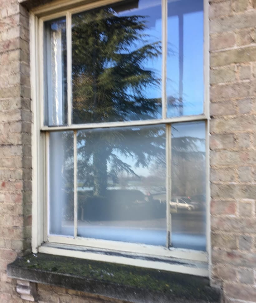A sash window with narrow margin panes down both sides of each sash and a wide pane in the middle