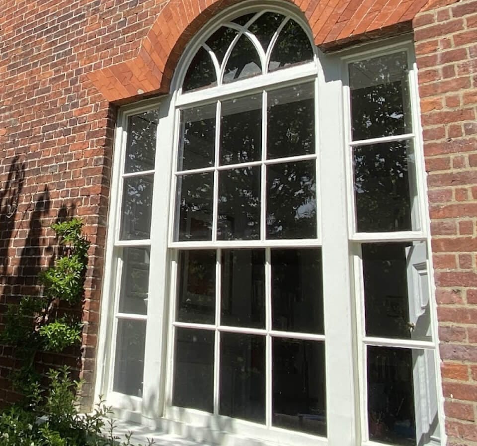 A Venetian window in a red-brick wall: an arched centre sash with a fanlight between two narrow sashes